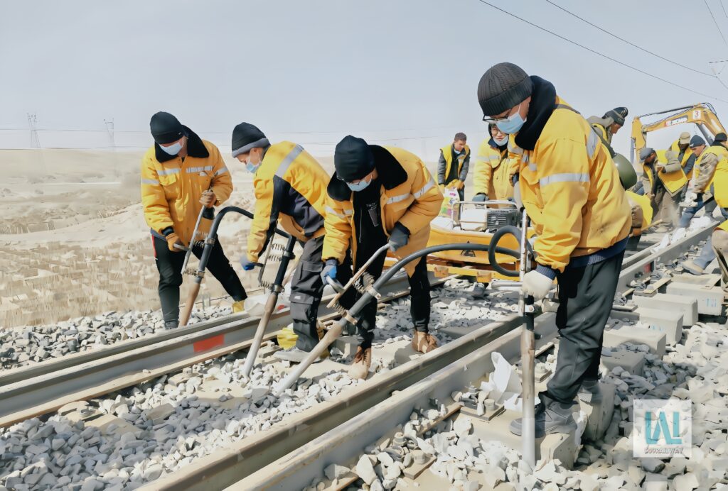 Workers performing railway track maintenance on site in China.